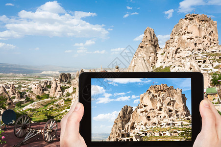 旅行概念春季土耳其卡帕多西亚智能手机上岩石切割Uchisar城堡的旅游照片图片