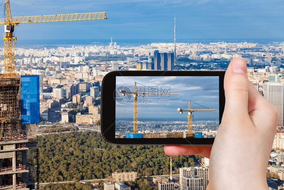 旅游概念秋季在莫斯科市建造的摩天大楼顶的起重机在俄罗斯智能手机上的旅游照片图片