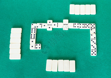 Dominoes棋盘游戏的顶端视图绿色面包桌上有白瓷砖的牌棋盘游戏图片