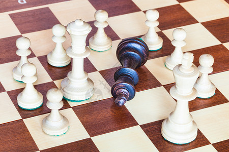 商业概念堕落的黑象棋王周围环绕着白象棋图片