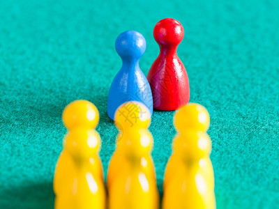 场景概念蓝色和红的棋子在队前一对绿色烤肉桌上的黄棋子专注在对上图片