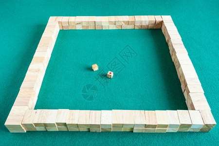 开始在绿色烤肉桌上打麻将瓷砖的战略棋盘游戏图片