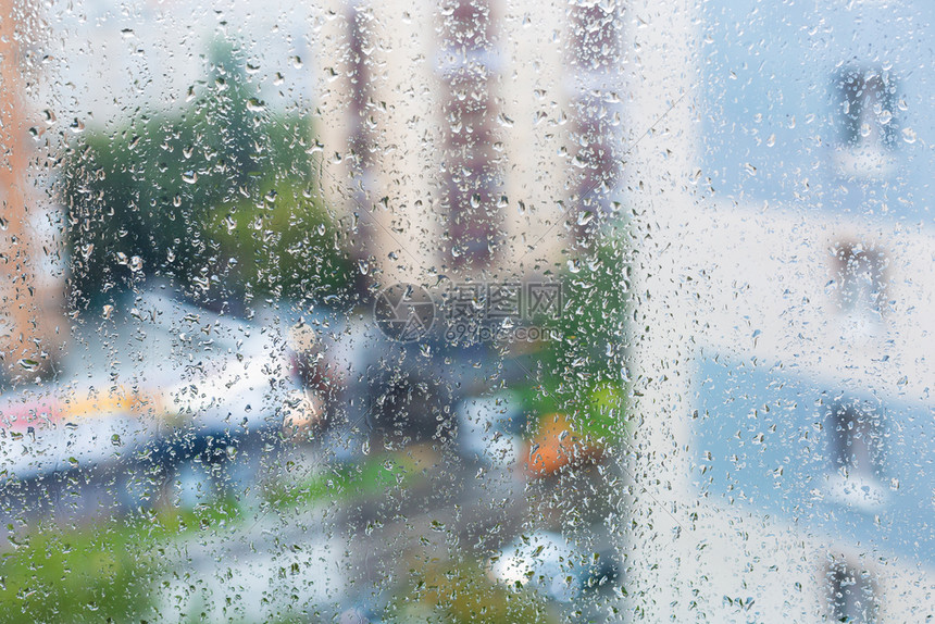 窗玻璃上的雨滴和秋天背景上的模糊城市街道图片