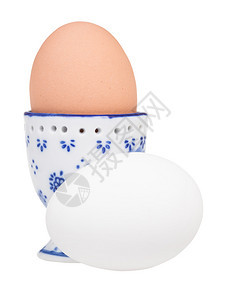 陶瓷鸡蛋杯和白底蛋中褐色煮和白的一面视图图片