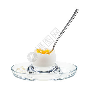白底隔绝的玻璃鸡蛋杯中勺子的开放软煮白蛋侧边视图图片