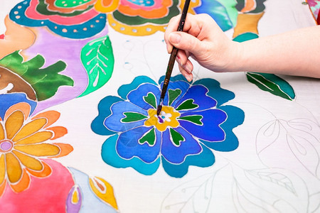艺术家在白色丝绸帆布上用冷蜡染工艺画出花朵艺术家在丝绸帆布上用蜡染画花朵图片