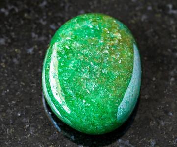 以印度黑花岗岩为背景的绿色Aventurine宝石绿色Aventurine宝石为黑色的Aventurine宝石图片