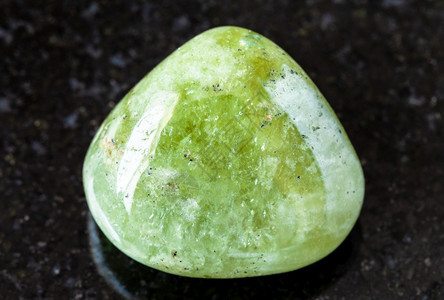 从地质采集的自然矿物样本封存以来自马里的黑花岗岩为背景的粗状Grossular绿色garnet岩石图片