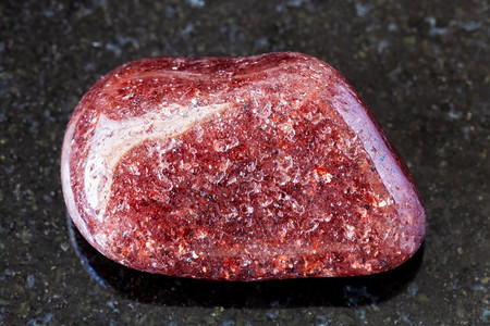 加拿大黑花岗岩背景的红硫酸宝石黑白上的红硫酸图片