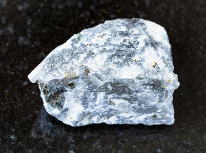 地质采集的天然矿物样本封存黑花岗岩背景的未排污梅利托岩图片