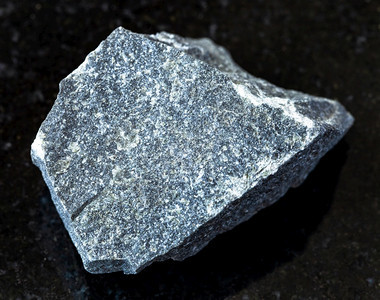 地质采集的自然矿物样本查封黑花岗岩背景的安第斯石图片