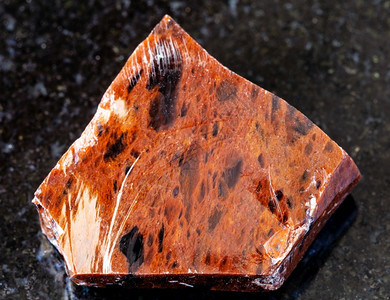 地质采集的自然矿物样本查封黑花岗岩背景的粗木马霍加尼奥布西迪亚岩图片