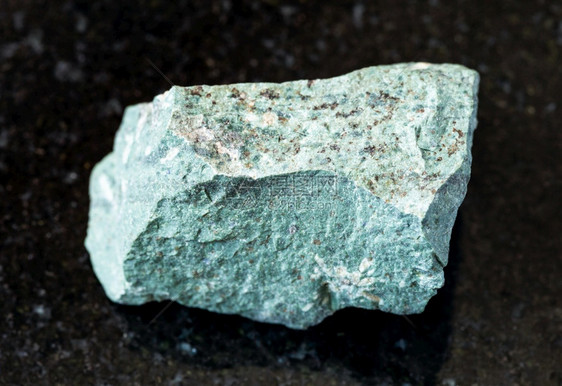 地质采集中自然矿物样本的查封黑花岗岩背景的Tinguaite岩石图片