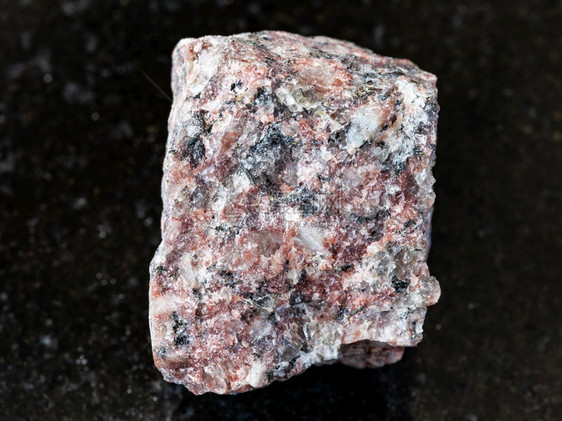 地质采集的天然矿物样本查封黑色花岗岩背景的粗粉红色花岗岩图片