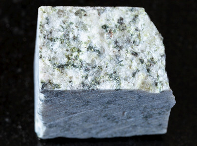 地质采集的天然矿物样本封存黑色花岗岩背景的原白花岗岩图片