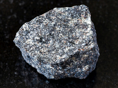 地质采集的自然矿物样本封存黑花岗岩背景的粗NephelineSyenite岩石图片