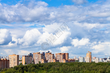 城市公寓楼和绿色城市公园的蓝天空中大白云图片