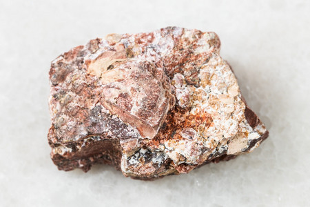 地质采集中自然矿物样本的查封白大理石背景上的原Rhyolite岩石图片