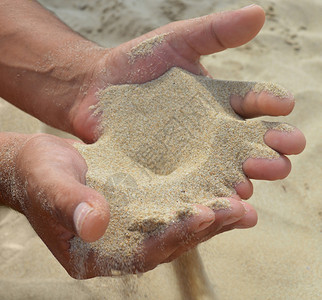 手掌海滩沙子从枣上流出图片素材