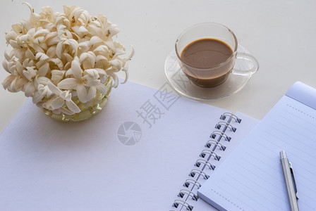 桌上摆放的笔记本咖啡和盆栽图片