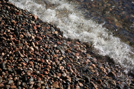对角线海边的波浪和小石头支撑海滩图片