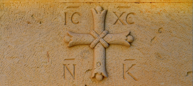 希腊石刻在块上的宗教象征物交叉希腊语背景图片