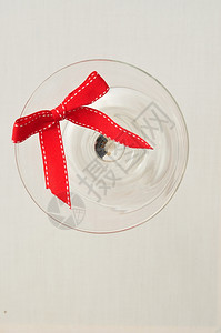装饰风格假期材料白色背景上隔绝的玻璃杯中红色丝带图片