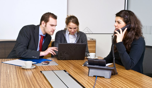 电话会议期间在隔室的小型商业组会议期间的一个小会议室打电话团队图片