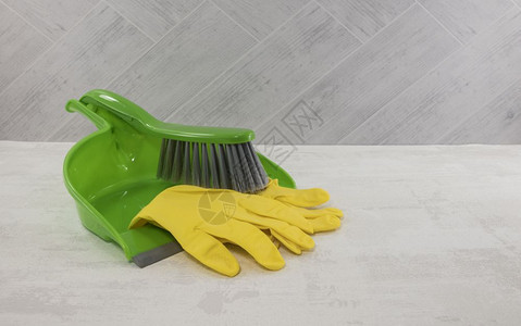 工具塑料绿色和黄粉尘以及绿和黄雪地上的手套和绿色黄的螺旋打扫图片