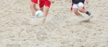 灰尘海滩沙足球腿踢子竞赛图片