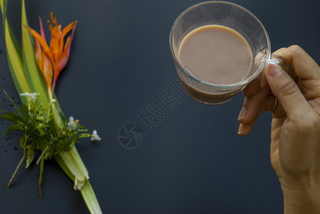 花一种杯咖啡在即将饮酒的女人手中此处叩头黑色的图片