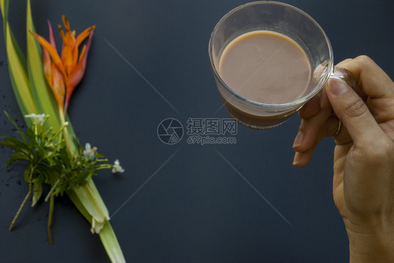 花一种杯咖啡在即将饮酒的女人手中此处叩头黑色的图片