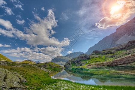 蓝天白云山坡下的湖水风光背景图片