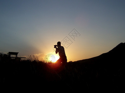落日和拍照的摄影师背景图片