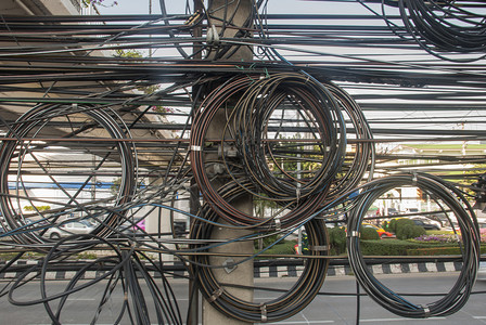 抽象的户外电混乱线紧贴在柱子上位于曼谷街道上图片