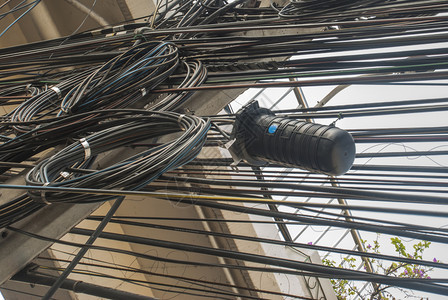 戳电缆户外混乱的线紧贴在柱子上位于曼谷街道上图片