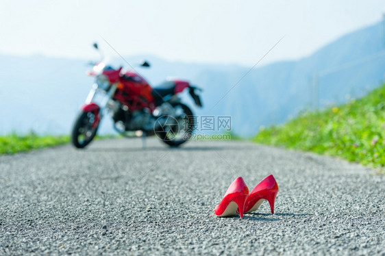 红色的摩托车一种红鞋和高跟在路上背着自行车图片