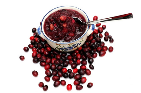 浆果最佳食用白背景的红莓酱和草上方的一碗红酱夹在白色背景上图片