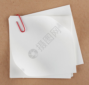 堆叠在纸板背景上贴有剪片的白纸红色空商业图片