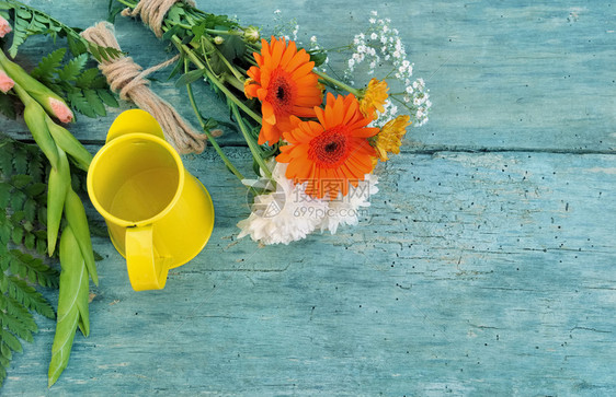 蓝色木板上鲜花束和黄色罐子生活丰富多彩的园艺图片