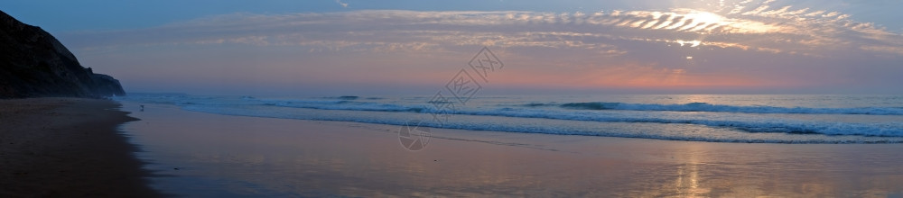 海洋日落时从葡萄牙ValeFigueiras海滩的全景谷菲格拉斯图片