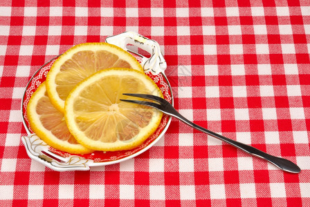酸的食物柠檬和叉子放在盘上的柠檬多汁图片