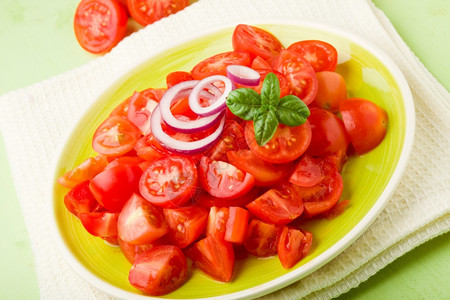 开胃菜番茄新鲜切樱桃西红柿加洋葱和绿色盘子上的烤肉图片