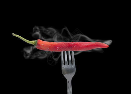 一种火红辣椒是用烟食物概念刺穿叉子的红辣椒热图片