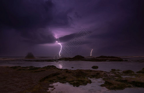 海滩夜晚黑暗的闪电大云和暴雨天气图片