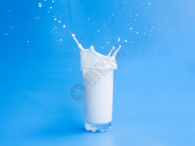 飞溅将牛奶倒出玻璃杯滴白色的图片