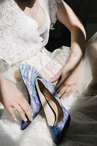 穿着白色婚纱的新娘拿着鞋子图片