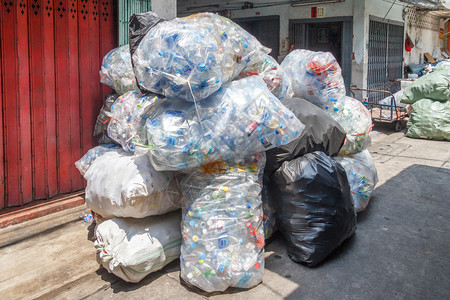 亚洲人等待再回收的塑料瓶袋泰国曼谷绿色麻袋图片