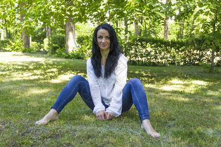 一月二十二十欧裔女坐在绿草上的照片色黑发背景