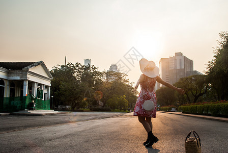 美丽的日落女青年在夏夕阳的天空中放松户外自由风格轮廓图片